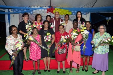 President Donald Ramotar (third from right in back row) with women honoured for their contributions at a State House ceremony yesterday to mark International Women’s Day. (GINA photo)