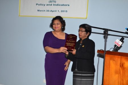 Education Minister Priya Manickchand (left) presents the posthumous award to wife of the late Navin Chandarpal, Indranie Chandarpal (GINA photo)
