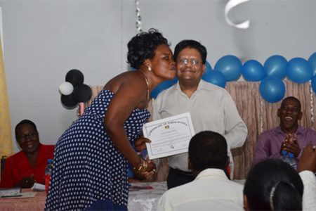 A very happy participant receiving her certificate from Finance Minister, Dr. Ashni Singh at the Basic Needs Trust Funds (BNTF), Beterverwagting ICT graduation ceremony. (GINA photo)