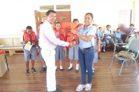 District Education Officer Ignatius Adams (left) receiving life jackets from a MARAD employee. (MARAD photo)