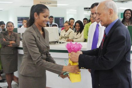 Nanda Persaud receiving her award from Bank Chairman Yesu Persaud.