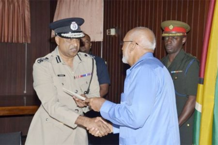 Police Commissioner Seelall Persaud (left) receiving his appointment certificate from President Donald Ramotar (GINA photo)