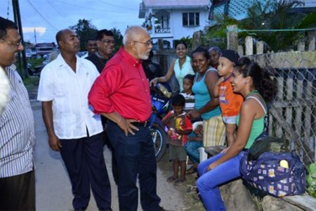 President Donald Ramotar (centre) sharing a light moment with a group of residents in Rose Hall, Berbice (GINA photo)