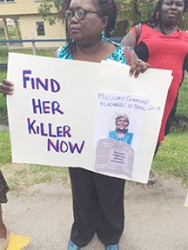 Coordinator Roxanne Myers holding a placard 