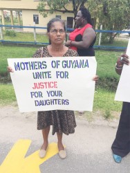 Babita Sarjou’s mother holding a Placard