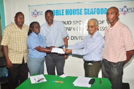 Secretary of the  GCA Deborah McNichol receives the cheque from Noble House Seafoods representative Percy Corlette.