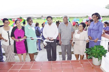 Minister of Finance, Dr Ashni Singh (centre), General Manager of the National Insurance Scheme, Doreen Nelson (third from left) and former General Manager Patrick Martinborough (third from right) during the cutting of the ribbon to commission the complex (GINA photo) 