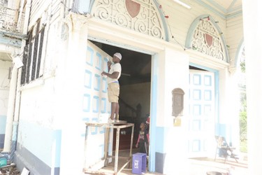 A worker painting the door at the Avenue of Republic entrance to City Hall, which will be used for next week’s nomination day activities 