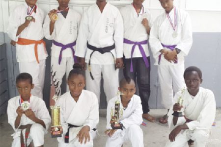 Members of the successful Black Cobra Karate Club of Parfaite Harmonie alongside sensei Lloyd Ramnarine (centre) displaying their respective medals and trophies earned during the Guyana Classic of Classic Martial Arts Tourney