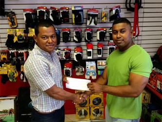 Organizing Secretary of the GABBFF, Videsh Sookram (right) receiving the sponsorship cheque from Fitness Express’ manager Ian Rogers yesterday at the company’s 47 John and Sheriff Streets location. 