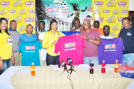 Sherwin `Lalai’ Grimes of Globe Yard receiving his team’s uniform from Busta Brand Manager Christine Kellawan while other members of the participating teams, Petra Organization Co-Director Troy Mendonca (2nd from left) and Managing Director of Guyana Beverage Company Robert Selman (right) look on.