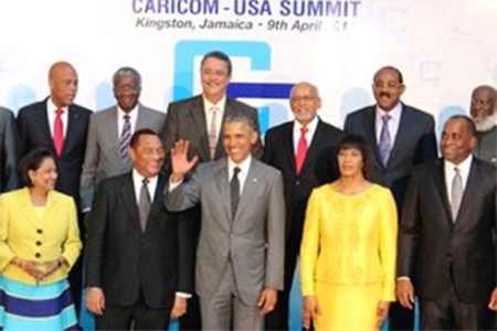 Prime Minister Kamla Persad-Bissessar, left front row, is all smiles as she looks at a waving United States President Barack Obama prior to a meeting with leaders of CARICOM countries at the Mona Campus of the University of the West Indies, Kingston, Jamaica, yesteday afternoon. The Prime Minister of Jamaica, Portia Simpson-Miller, on the right of the President, welcomed the US President to her country. Perry Christie, Prime Minister of the Bahamas, and Chairman, of CARICOM, next to the President, in welcoming Obama, raised issues which CARICOM needed to be addressed. (Trinidad Express photo)
