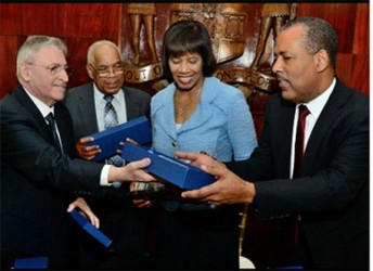 President of Terminal Link and Executive Officer of CMA CGM Group, Farid Salem (left) presents gifts to Minister of Transport Dr Omar Davies (second left), Prime Minister Portia Simpson Miller, and President/CEO of the Port Authority of Jamaica Professor Gordon Shirley (right) at the signing ceremony for the 30-year concession agreement for Kingston Container Terminal, at the Office of the Prime Minister, Kingston on April 7, 2015.