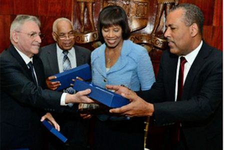 President of Terminal Link and Executive Officer of CMA CGM Group, Farid Salem (left) presents gifts to Minister of Transport Dr Omar Davies (second left), Prime Minister Portia Simpson Miller, and President/CEO of the Port Authority of Jamaica Professor Gordon Shirley (right) at the signing ceremony for the 30-year concession agreement for Kingston Container Terminal, at the Office of the Prime Minister, Kingston on April 7, 2015.