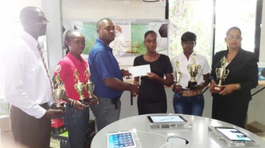 Fruta Conquerors President Wayne Force (3rd from left) receiving the sponsorship cheque from I-Net representative Kenisha Wills while other members of the launch party inclusive of Club Secretary Daniel Thomas (left), GFA Assistant Secretary-Treasurer Charmaine Wade (2nd left), GFA President (Ag) Lavern Fraser Thomas (2nd from right) and Global Technology Human Resources Manager Jacqueline Weeks look on 