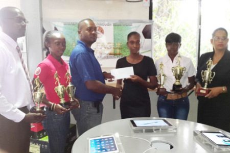 Fruta Conquerors President Wayne Force (3rd from left) receiving the sponsorship cheque from I-Net representative Kenisha Wills while other members of the launch party inclusive of Club Secretary Daniel Thomas (left), GFA Assistant Secretary-Treasurer Charmaine Wade (2nd left), GFA President (Ag) Lavern Fraser Thomas (2nd from right) and Global Technology Human Resources Manager Jacqueline Weeks look on
