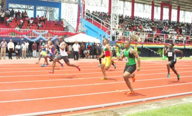 Rupert Perry (lane 4) in stride ahead of Kevin Abbensetts (lane 1) and Tevin Garraway (lane 6) in the first male 100m event at the National Track and Field Centre and Football Facility at Leonora yesterday. (Orlando Charles photo) 