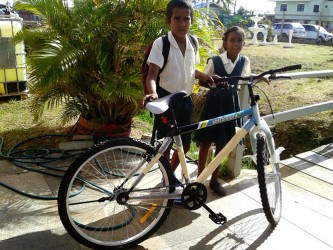 The two students who were picked up by St Francis Community Developers pose with their new bicycle.  