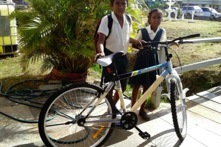 The two students who were picked up by St Francis Community Developers pose with their new bicycle.
