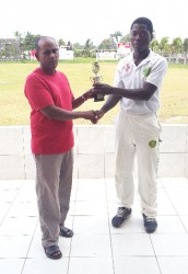 GCB Chairman of Junior National Selectors Nazimul Drepaul hands over the MVP trophy to Sherfane Rutherford. 