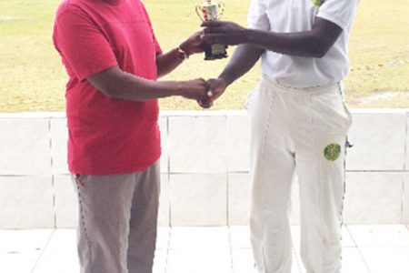 GCB Chairman of Junior National Selectors Nazimul Drepaul hands over the MVP trophy to Sherfane Rutherford.
