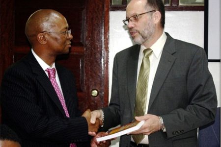 CARICOM Secretary-General, Irwin LaRocque (right) presents a copy of the Revised Treaty of Chaguaramas to Baso Sanqu, Chief Adviser to the Chairperson of the African Union Commission during a courtesy call at the CARICOM Secretariat on Thursday