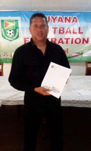 GFF Technical Director Claude Bolton displaying the newly created ‘Next Generation Project’ developmental manifesto following the end of the press conference