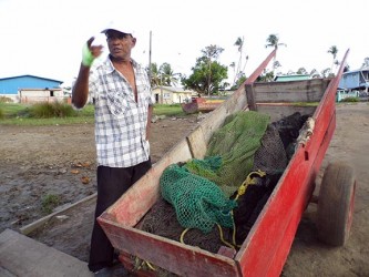 Christandat Jadundan explains how the fish pen is erected. (Photo by Jannelle Williams)