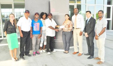 Guyana Marriott’s Director of Sales and Marketing, Denisse Olivo handing over the sponsorship cheque to Leslie Blacks yesterday in the presence of athletes and staff of the hotel. (Orlando Charles photo)