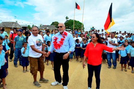 President Donald Ramotar (centre) and Amerindian Affairs Minister Pauline Sukhai (right) being welcomed by residents of Kurukabaru, Region Eight. (GINA photo) 