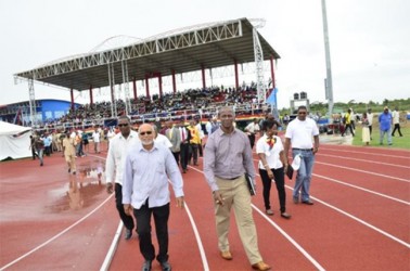 President Donald Ramotar and Permanent Secretary of the Culture,  Youth and Sport Ministry Alfred King walking around the synthetic track at the National Track and Field Center, at Leonora, West Coast Demerara (GINA photo)