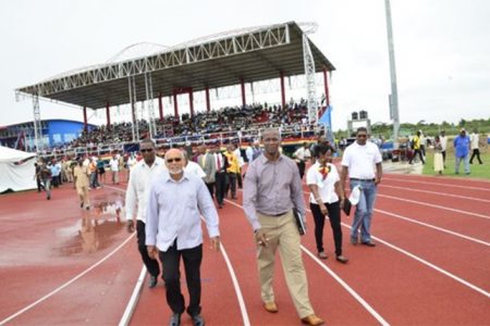 President Donald Ramotar and Permanent Secretary of the Culture,  Youth and Sport Ministry Alfred King walking around the synthetic track at the National Track and Field Center, at Leonora, West Coast Demerara (GINA photo)