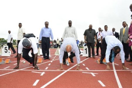 Preparing for the elections? A former athlete, President Donald Ramotar (centre), and Minister of Culture, Youth and Sport Dr. Frank Anthony (right) in the starting blocks on the synthetic track (GINA photo)