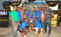 Captain of the victorious Amelia’s Ward Russian Travis Whatterton collecting the championship trophy from Banks DIH Representative Shondel Easton while Guinness Brand Manager Lee Baptiste (right) and other members of the team look on
