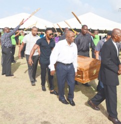The body of the late Calvin Roberts being carried by members of the media and sport fraternity under a guard of honour yesterday at the GNIC ground. 