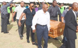 The body of the late Calvin Roberts being carried by members of the media and sport fraternity under a guard of honour yesterday at the GNIC ground.
