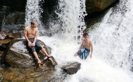 Relaxing under the cascading waters of the Kumu Falls