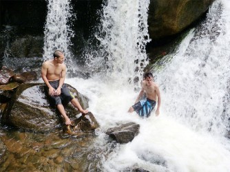 Relaxing under the cascading waters of the Kumu Falls