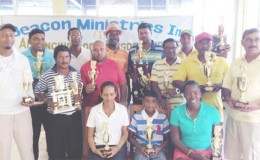 Dr London ( third, left back row) stands among the winners displaying their trophies: from  left to right, seated: Christine Sukhram, Lochan Ramroop and Shanella Webster; standing first row: Jetendra Dhanpat, Mike Mangal, David Mohamad, Kishan Bacchus, Sookram Deosarran, and Rabindranauth Persaud; standing back row – Kalyan Tiwari, Patrick Prashad and Richard Haniff and Avinda Kishore flank London. 
