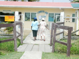 Elderly women assisting each other to vote at the Cumberland Nursery School in East Canje.