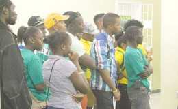APNU+AFC  supporters watching the GECOM press conference yesterday at its Crown and Albert Sts office.