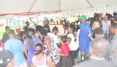 Mourners viewing the remains of Guyana’s first world boxing champion, Andrew ‘Sixhead’ Lewis yesterday at the Parade Ground. (Orlando Charles photo) 