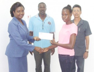  In picture, Human Resources Manager of Mings Products and Services Limited, Joy Lewis, hands over to Kenisha Phillips the sponsorship cheque while Director, Colin Ming and Coach, Linden Phillips look on. 