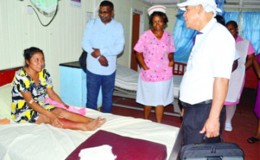 Minister of Public Health Dr. George Norton (right), accompanied by Chief Medical Officer Dr. Shamdeo Persaud and staff of the Bartica Hospital visiting a patient of the facility. (GINA photo)