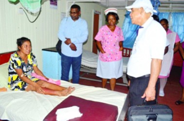 Minister of Public Health Dr. George Norton (right), accompanied by Chief Medical Officer Dr. Shamdeo Persaud and staff of the Bartica Hospital visiting a patient of the facility. (GINA photo) 