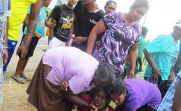 The mother of Deonarine Ramsarran being consoled by relatives at the scene.