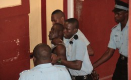 Policemen wrestling with Akeem Charles to take him back to the holding facility at the city courts complex, after he fled.
