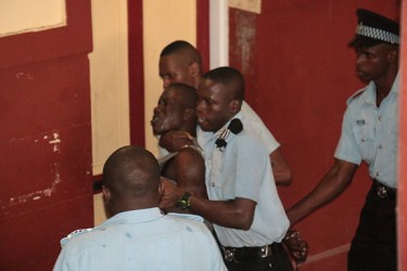 Policemen wrestling with Akeem Charles to take him back to the holding facility at the city courts complex, after he fled.