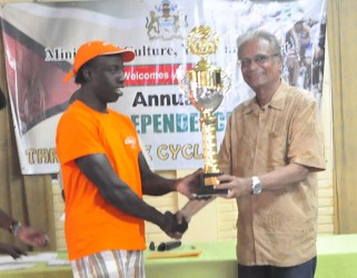 Orville Hinds receiving the trophy from Education Minister Dr. Rupert Roopnaraine