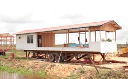 Workers constructing a mobile office with bedroom and toilet at Schoonord, West Demerara at Boodhoo's Housing Scheme.